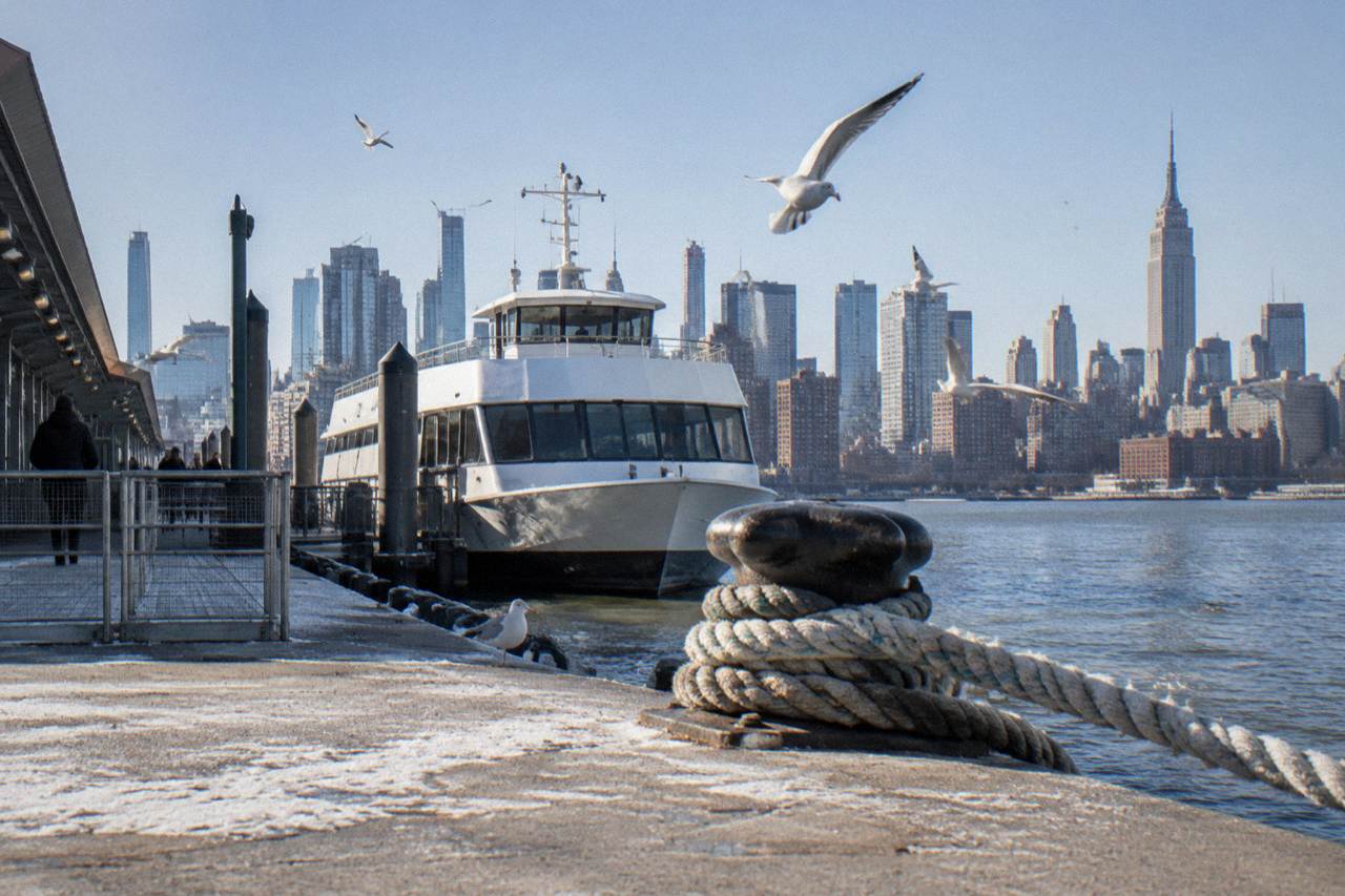 A sightseeing boat on the Hudson River with the Manhattan skyline behind it