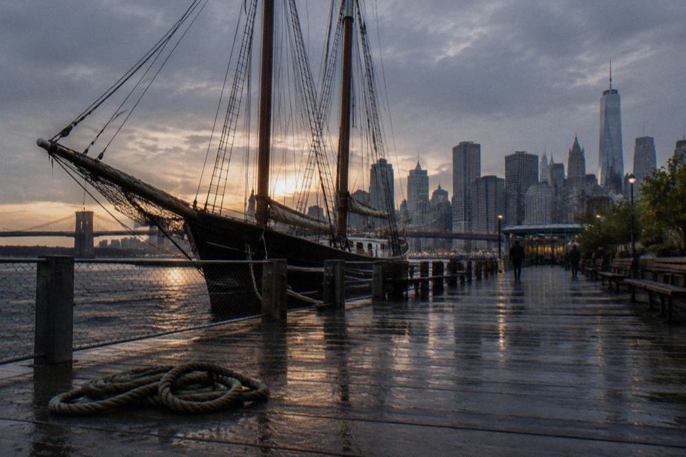 A schooner under sail on the Hudson River with sunset light on the water