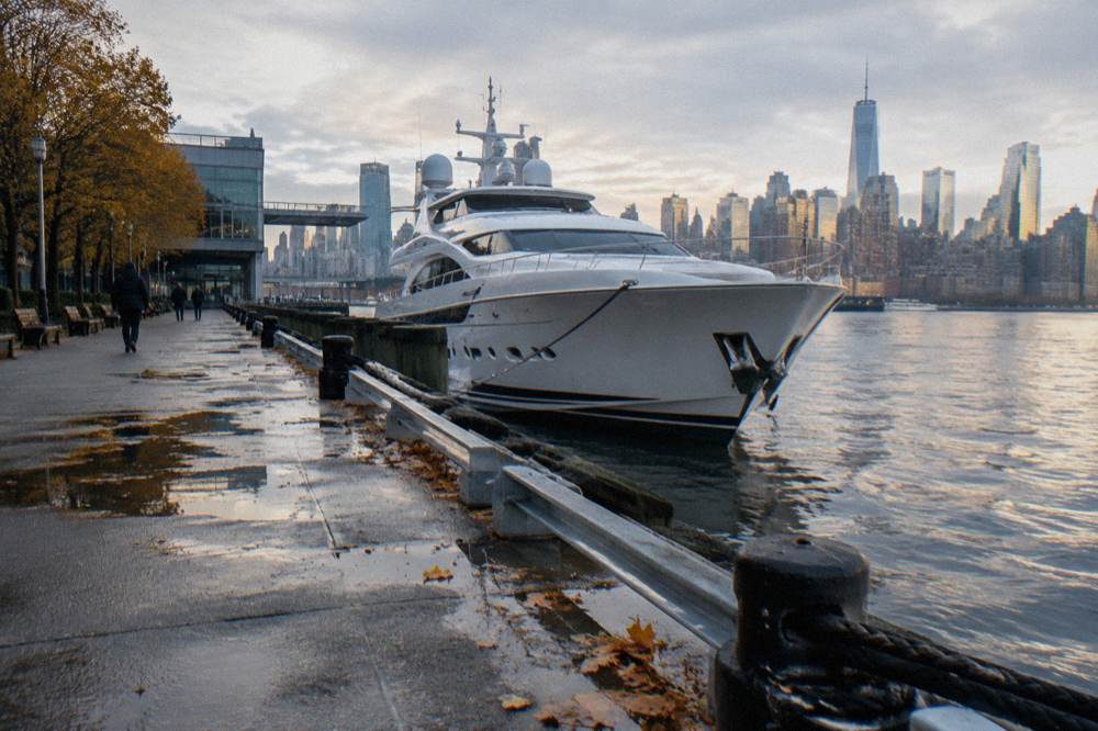 A luxury yacht at a Chelsea Piers berth with the Hudson River and skyline behind it