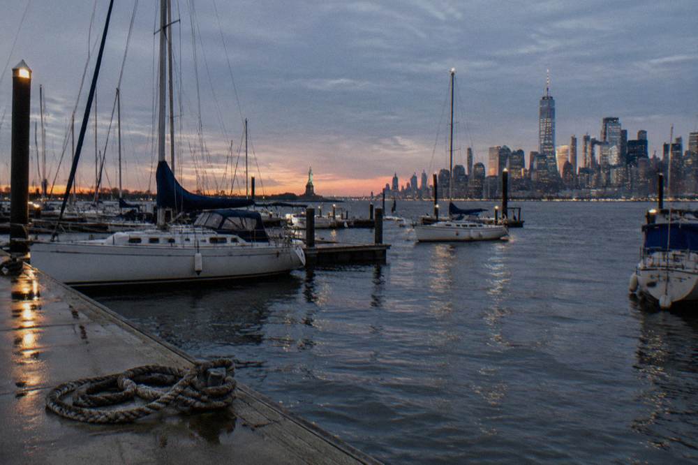 The Statue of Liberty and the Manhattan skyline seen together from a New Jersey shoreline park