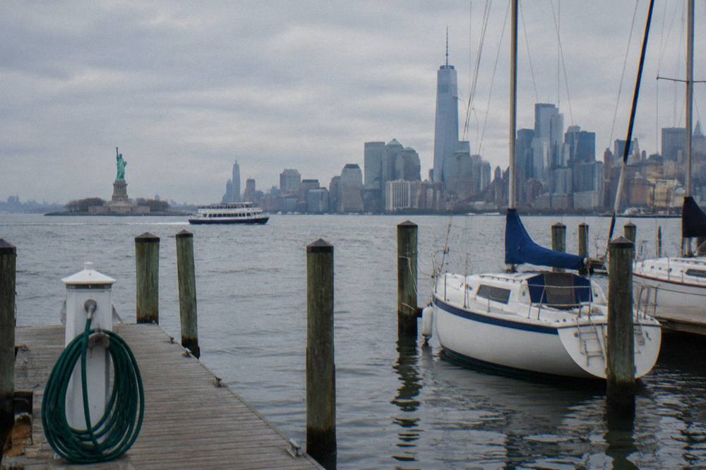 A sightseeing cruise boat passing the Statue of Liberty in New York Harbor