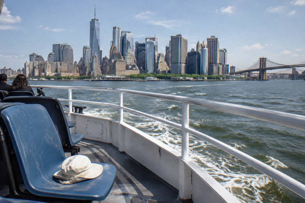 The Manhattan skyline seen from the water at midday with a cruise boat deck in the foreground