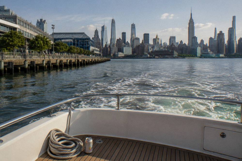 A cruise boat approaching the Manhattan skyline on a clear afternoon