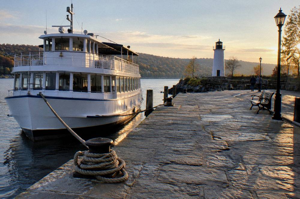 Historic stone dock with a river cruise boat tied up at a small upstate waterfront town