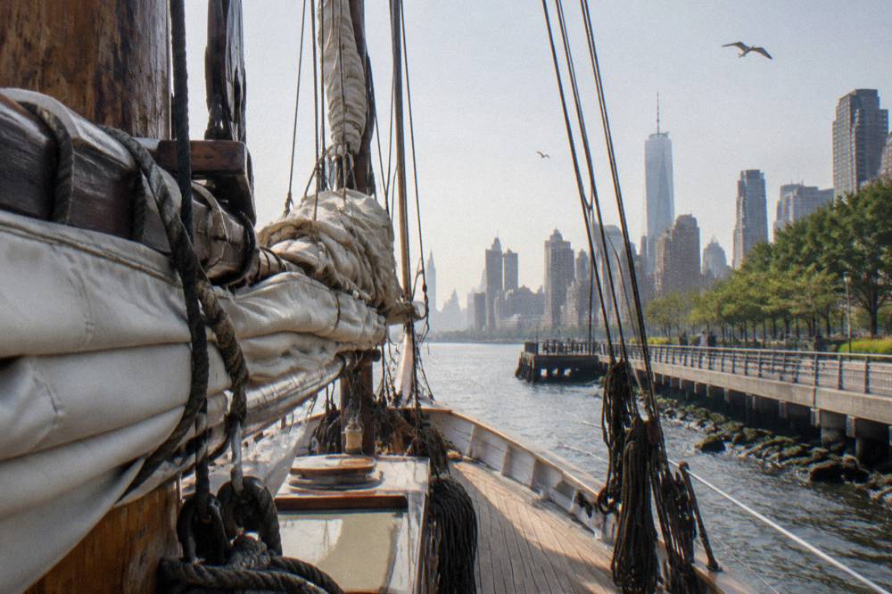 Close view of furled canvas sails and wooden rigging on a schooner mast
