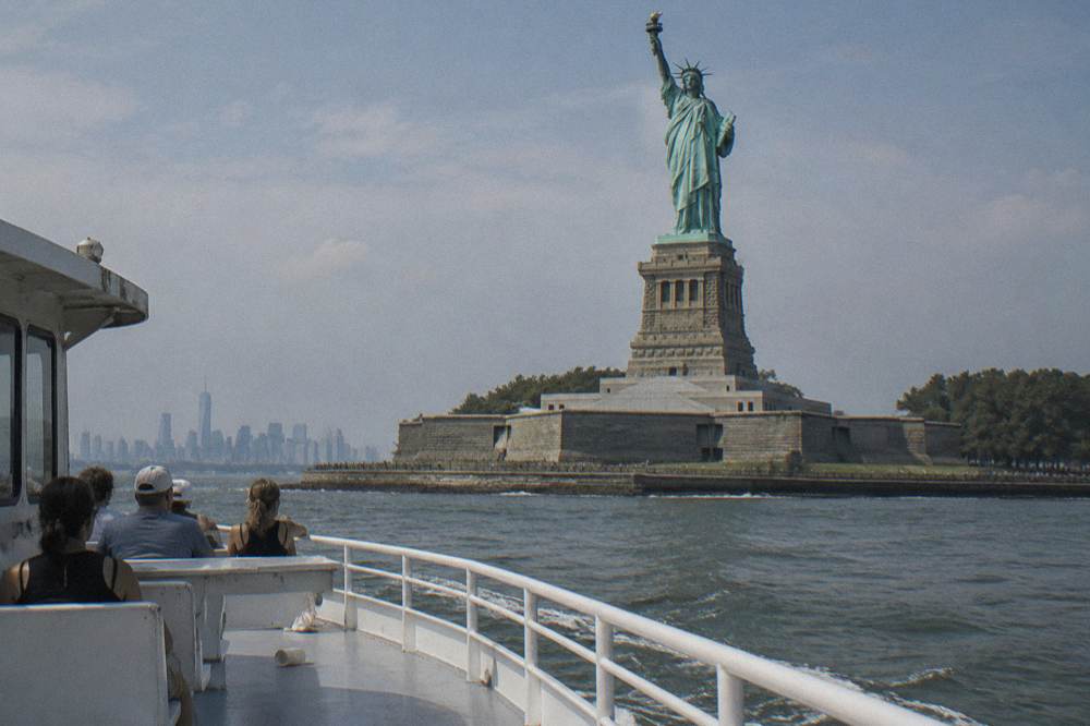 A tour boat passing close to the Statue of Liberty in New York Harbor