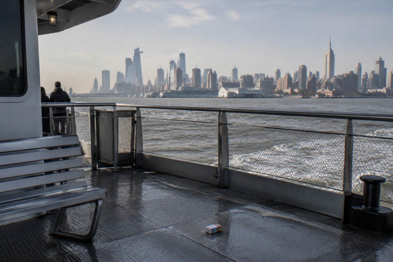 Open deck of a sightseeing boat on the Hudson River with the Manhattan skyline across the water