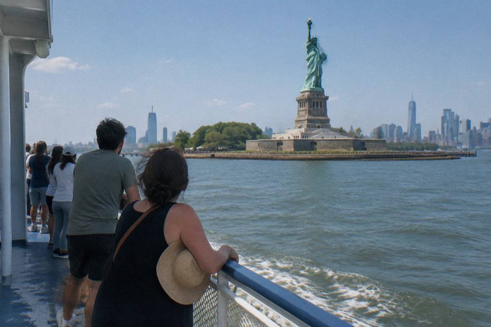 Passenger deck of a harbor cruise boat with railing views toward lower Manhattan.
