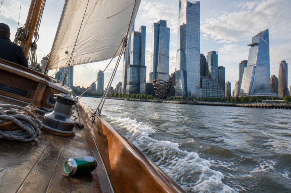 Schooner under sail on the Hudson River with the Manhattan skyline behind.
