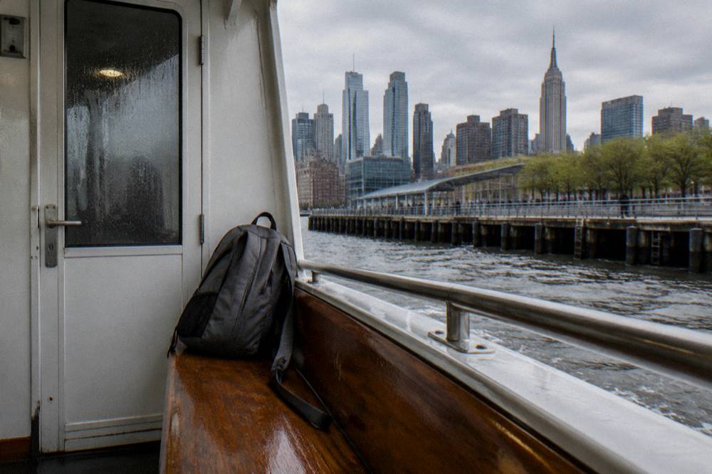 Small daypack resting on a bench beside a cabin door on a cruise boat.
